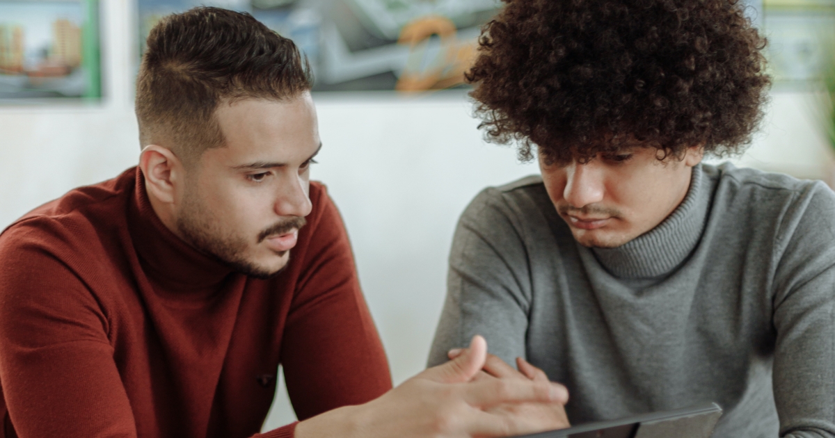 Two people looking on a computer